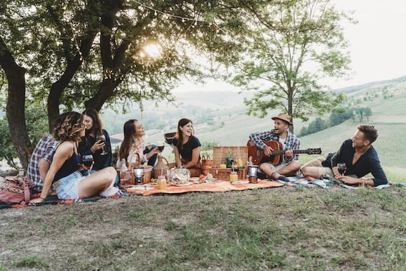 Freunde picknicken und jemand spielt Gitarre